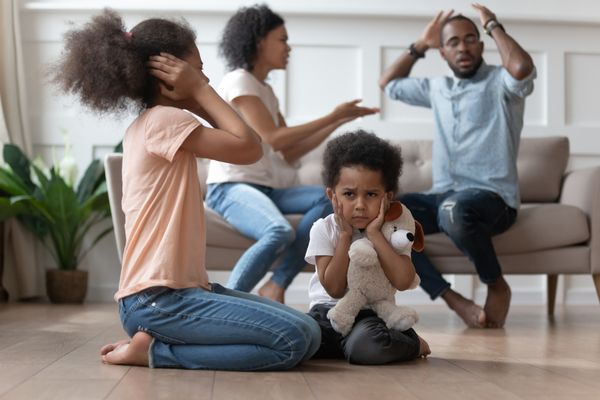couple arguing with two children in foreground - domestic violence concept