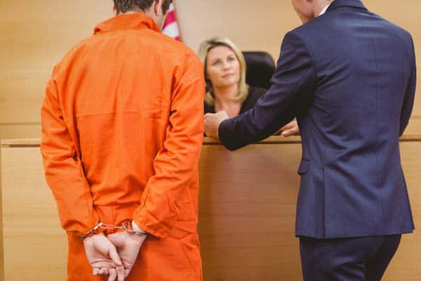 Nashville criminal defense lawyer talking to judge next to prisoner