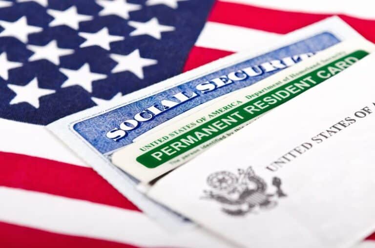 Image is of a social security card, a permanent resident card and an American flag, concept of 'Will a DUI conviction affect my immigration status'?